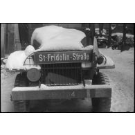 Plaque de rue allemande installée sur la calandre d'un camion GMC de la 297e compagnie du Train de la 2e division blindée (2e DB).