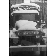 Plaque de rue allemande installée sur la calandre d'un camion GMC de la 297e compagnie du Train de la 2e division blindée (2e DB).