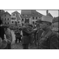 Lors de sa visite à Saverne, au cours d'une cérémonie, le général de Gaulle remet les insignes de grand-officier de la Légion d'honneur et la croix de Guerre au lieutenant général américain Jacob Devers, commandant le 6e groupe d'armées,