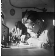 Camion atelier de réparation des appareils d'optique du groupe d'escadrons de réparation (GER XV) de la 2e division blindée (2e DB) : réparation d'un épiscope de tourelleau de blindé.