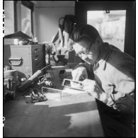 Camion atelier de réparation des appareils d'optique du groupe d'escadrons de réparation (GER XV) de la 2e division blindée (2e DB) : réparation d'un épiscope de tourelleau de blindé.