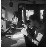 Camion atelier de réparation des appareils d'optique du groupe d'escadrons de réparation (GER XV) de la 2e division blindée (2e DB) : réparation de jumelles binoculaires.