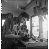 Camion atelier de réparation des appareils d'optique du groupe d'escadrons de réparation (GER XV) de la 2e division blindée (2e DB) : réparation d'un dispositif de visée de blindé.