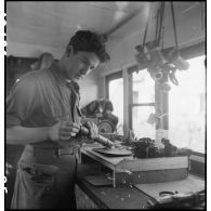 Camion atelier de réparation des appareils d'optique du groupe d'escadrons de réparation (GER XV) de la 2e division blindée (2e DB) : réparation d'un dispositif de visée de blindé.