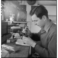 Camion atelier de réparation des appareils d'optique du groupe d'escadrons de réparation (GER XV) de la 2e division blindée (2e DB) : réparation d'une paire de jumelles.