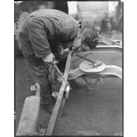 Soudure d'un châssis de jeep dans l'atelier de réparation automobile de la compagnie mixte de transmissions 97/84 de la 2e division blindée (2e DB).