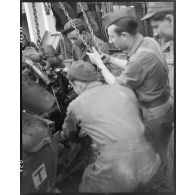 Mise en place ou dépose d'un moteur de jeep à l'aide d'un palan par des mécaniciens de la section matériel de la compagnie mixte de transmissions 97/84 de la 2e division blindée (2e DB).