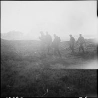 Des prisonniers allemands accompagnent un zouave brancardier du 4e régiment de zouaves (4e RZ) pour relever des blessés sur le terrain.