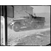 Un half-track de la 32e batterie du 64e régiment d'artillerie (64e RADB) de la 2e division blindée (2e DB) traverse une commune pour monter au front dans le secteur de Royan.
