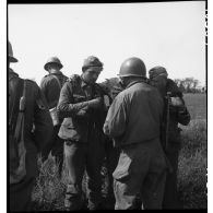 Des prisonniers allemands sont fouillés par des hommes de la 2e division blindée (2e DB) et des Forces françaises de l'Ouest  (FFO) dans le secteur de Royan, sur la route départementale entre Saujon et la La Tremblade.