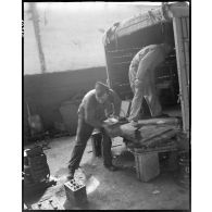 Déchargement de batteries d'un camion dans l'atelier de réparation automobile de la compagnie mixte de transmissions 97/84 de la 2e division blindée (2e DB).