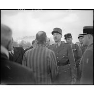 Le général de corps d'armée Pierre Koenig, gouverneur militaire de Paris, s'entretient avec un déporté politique à l'issue d'une cérémonie de ravivage de la flamme sur la tombe du Soldat inconnu.