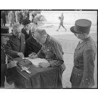 Un déporté politique signe le livre d'or à l'issue d'une cérémonie de ravivage de la flamme sur la tombe du Soldat inconnu à l'Arc de Triomphe.