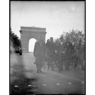 Des déportés politiques s'éloignent de l'Arc de Triomphe à l'issue d'une cérémonie de ravivage de la flamme sur la tombe du Soldat inconnu.