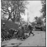 Un soldat nord-africain, blessé lors d'un accrochage devant Fützen, est évacué sur un brancard par une équipe médicale et des marsouins de la 9e division d'infanterie coloniale (9e DIC).