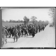 Prisonniers de guerre allemands sur une route encadrés par l'armée américaine pour rejoindre un camp vers l'arrière.