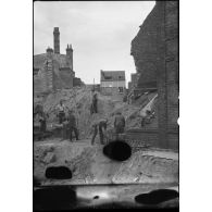 Des prisonniers allemands déblaient une zone bombardée dans Dunkerque.