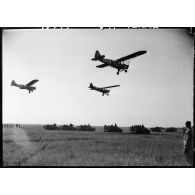 Des Piper Cub de la 25e section d'observation d'aviation d'artillerie (25e SOAA) de la 2e division blindée (2e DB) survolent le défilé motorisé de la division sur un aérodrome à proximité d'Augsbourg.