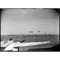 Des Piper Cub survolent des automitrailleuses lors d'un défilé à l'issue d'une prise d'armes de la 2e division blindée (2e DB) sur un aérodrome au nord d'Augsbourg.