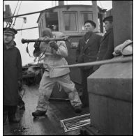 A bord d'un chalutier, un marin canonnier utilise un télémètre de 0,80 modèle 1935 (sous réserves).