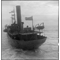 Poupe d'un cargo britannique croisant la route d'un chalutier.