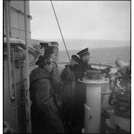 Un enseigne de vaisseau, des officiers mariniers et des matelots sont de veille à la passerelle du torpilleur Bouclier ou Flore.