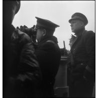 Un lieutenant de vaisseau et un enseigne observent l'horizon aux jumelles sur la passerelle du torpilleur Bouclier ou Flore.