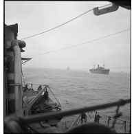 Un torpilleur, le Bouclier ou le Flore, escorte et ouvre la voie à un convoi de cargos de la marine marchande.