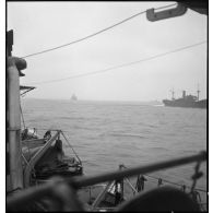Un torpilleur, le Bouclier ou le Flore, escorte et ouvre la voie à un convoi de cargos de la marine marchande.