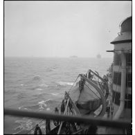 Un torpilleur, le Bouclier ou le Flore, escorte et ouvre la voie à un convoi de cargos de la marine marchande.