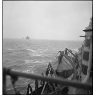 Un torpilleur, le Bouclier ou le Flore, escorte et ouvre la voie à un convoi de cargos de la marine marchande.