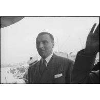 Louis Jacquinot, commissaire à la Marine, monte à bord de l'escorteur l'Algérien à quai dans le port d'Alger.