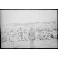Les autorités militaires saluent le drapeau du 1er régiment de tirailleurs algériens (1er RTA) sur un quai du port d'Alger.