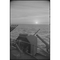 Coucher de soleil depuis un poste d'artillerie sous masque d'un navire de la Marine nationale.