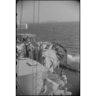 Plage avant d'un croiseur naviguant au large d'une côte.