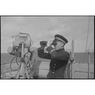 L'enseigne de vaisseau commandant le chalutier Vikings, réquisitionné et armé en patrouilleur par la Marine nationale, observe l'horizon.