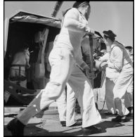Des canonniers chargent un obus dans le fût d'un canon à bord du torpilleur Simoun.