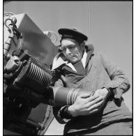 Un canonnier charge un obus dans le fût d'un canon à bord du  torpilleur Simoun.