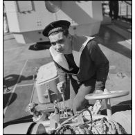 Marin actionnant un treuil à bord du torpilleur Simoun.