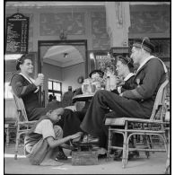 Des marins du torpilleur Simoun, descendus à terre, sont attablés à la terrasse d'un café.