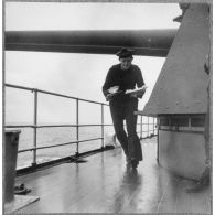 Un matelot, maître d'hôtel à bord du cuirassé Dunkerque, apporte un repas au vice-amiral Marcel Gensoul à bord du cuirassé Dunkerque.