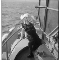 Lieutenant de vaisseau de veille aux jumelles à hauteur de la passerelle à bord du cuirassé Dunkerque.