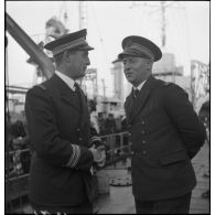 Le capitaine de frégate Jacques Lapébie, commandant le torpilleur le Siroco (ou Sirocco), et le capitaine de corvette Le Floch, commandant l'aviso Commandant Duboc, conversent à l'occasion de la visite du président du Conseil à Cherbourg.