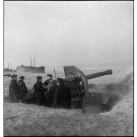 Un canon de 155 mm servi par des marins canonniers d'une unité de défense côtière, en batterie le long du littoral du Nord-Pas-de-Calais.