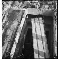 Dans le port de New-York pris par les glaces, une caisse qui contient un avion destiné aux Alliés est descendue dans la cale d'un cargo.