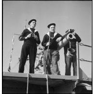 Des canonniers observent l'horizon depuis la plate-forme sur laquelle se trouve le canon de 90 mm du pétrolier Bourgogne.