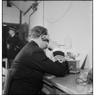 Un commander de la Royal Navy est au téléphone dans le poste de commandement (bastion 32) de l'amiral Abrial à Dunkerque.