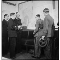 Point de situation devant une carte murale au poste de commandement de l'amiral Abrial.