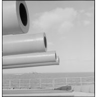 Tourelle quadruple de canons de 330 mm sur le pont avant du cuirassé Dunkerque. A l'arrière-plan, le contre-torpilleur Le Malin.