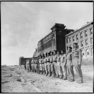 Membres des Forces françaises de l'intérieur (FFI) rassemblés arme au pied devant l'Ecole navale de Brest lors de la visite de Louis Jacquinot, ministre de la Marine.